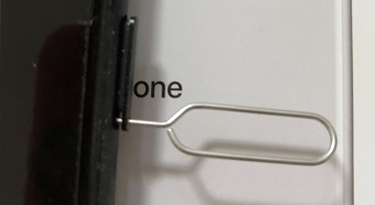 iPhoneの側面にある丸い穴にSIMピンを挿す