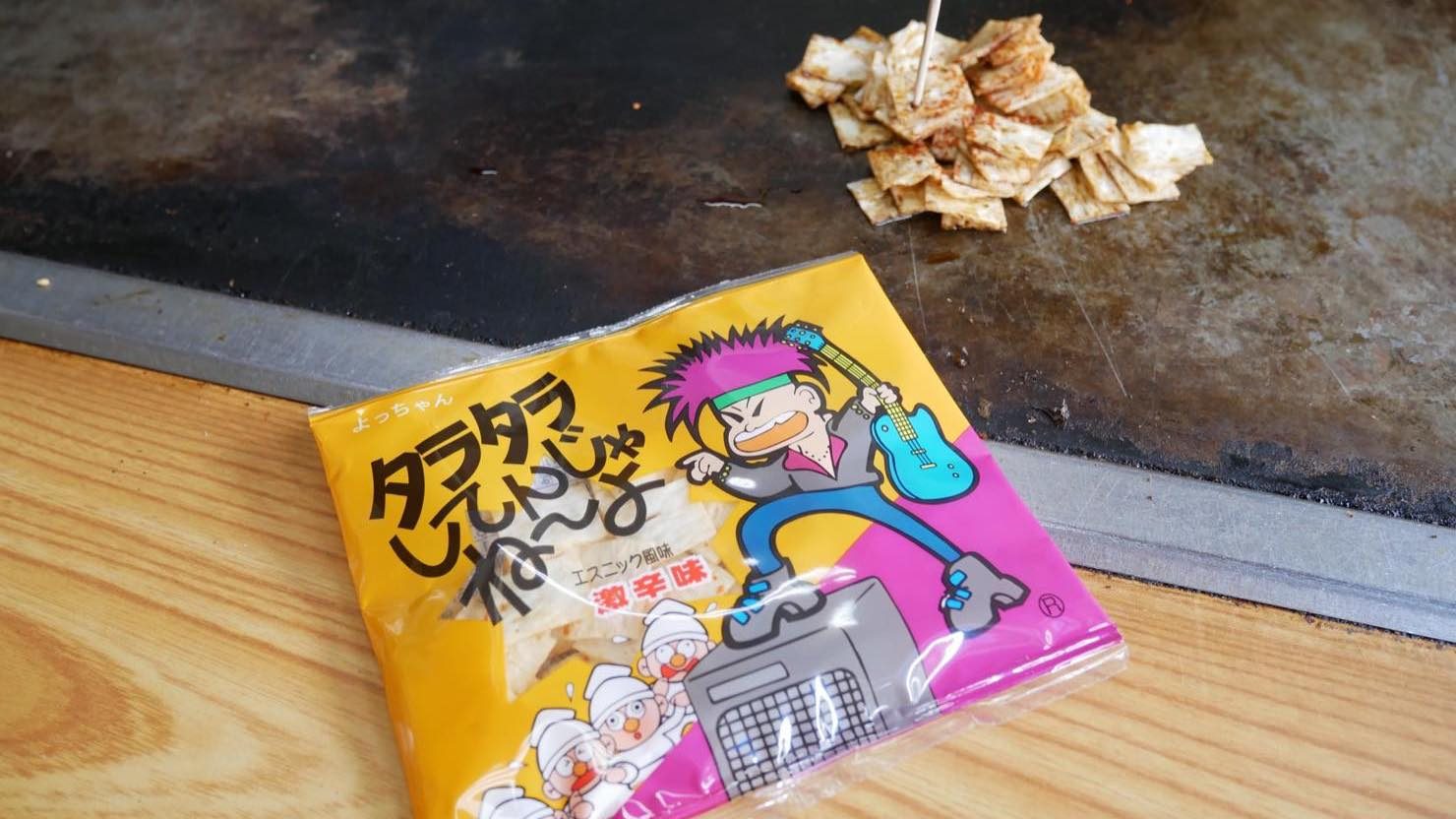 「タラタラしてんじゃね～よ」（よっちゃん食品工業株式会社）を鉄板で焼いて醤油と一味唐辛子をかけた「こんじょう焼き」80円。“エスニック風味激辛味”の駄菓子に、さらに一味唐辛子を振りかけて食べることから付けられたメニュー名だそう。辛いもの食べて根性入れろ！という感じでしょうか。パンチの効いたネーミングですね 