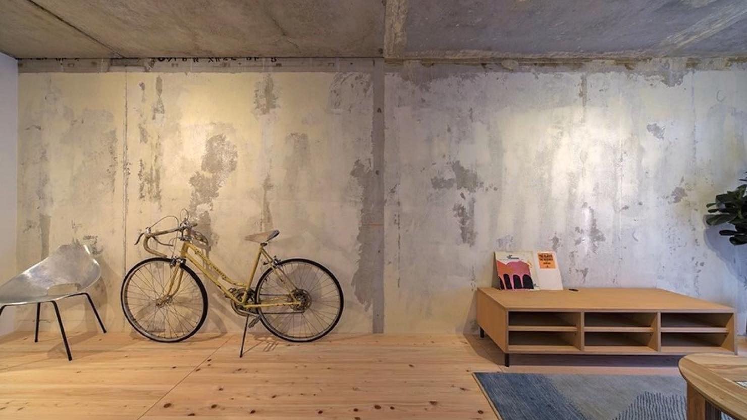 壁紙をめくっただけのLDKの壁面。床は地産地消の視点で選んだ大阪の間伐材。