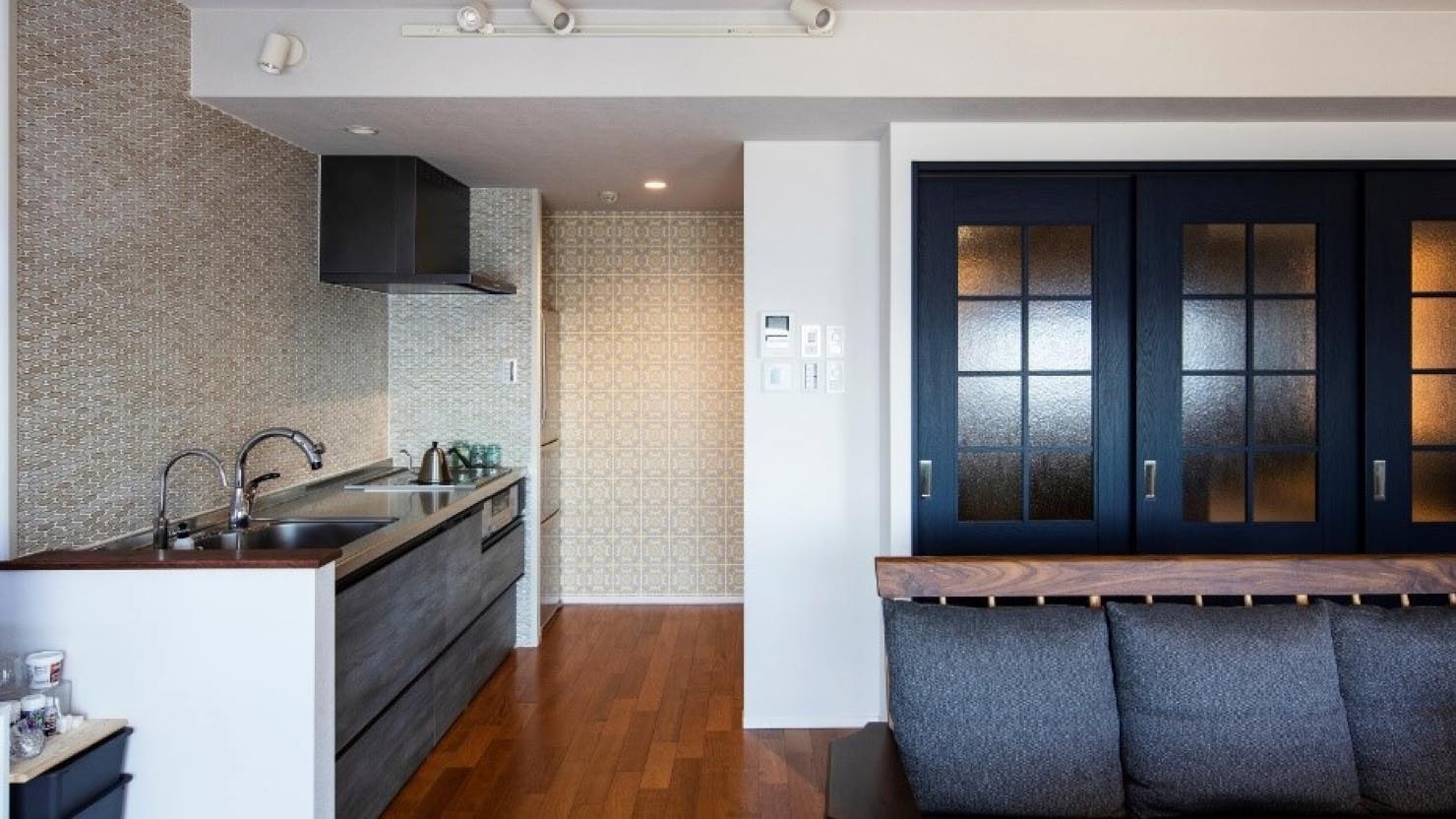 キッチン正面は、あえて柄物ではなくて照明の当たり方によってニュアンスが変わる素材感を選択。奥のクロスはタイルと同系色の柄ものを選び、全体的に地中海風になりました