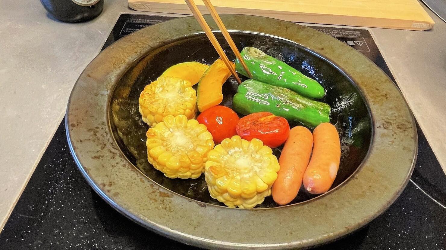 フライパンにもなるお皿で焼かれた野菜とソーセージ  © Fukuko Lynn