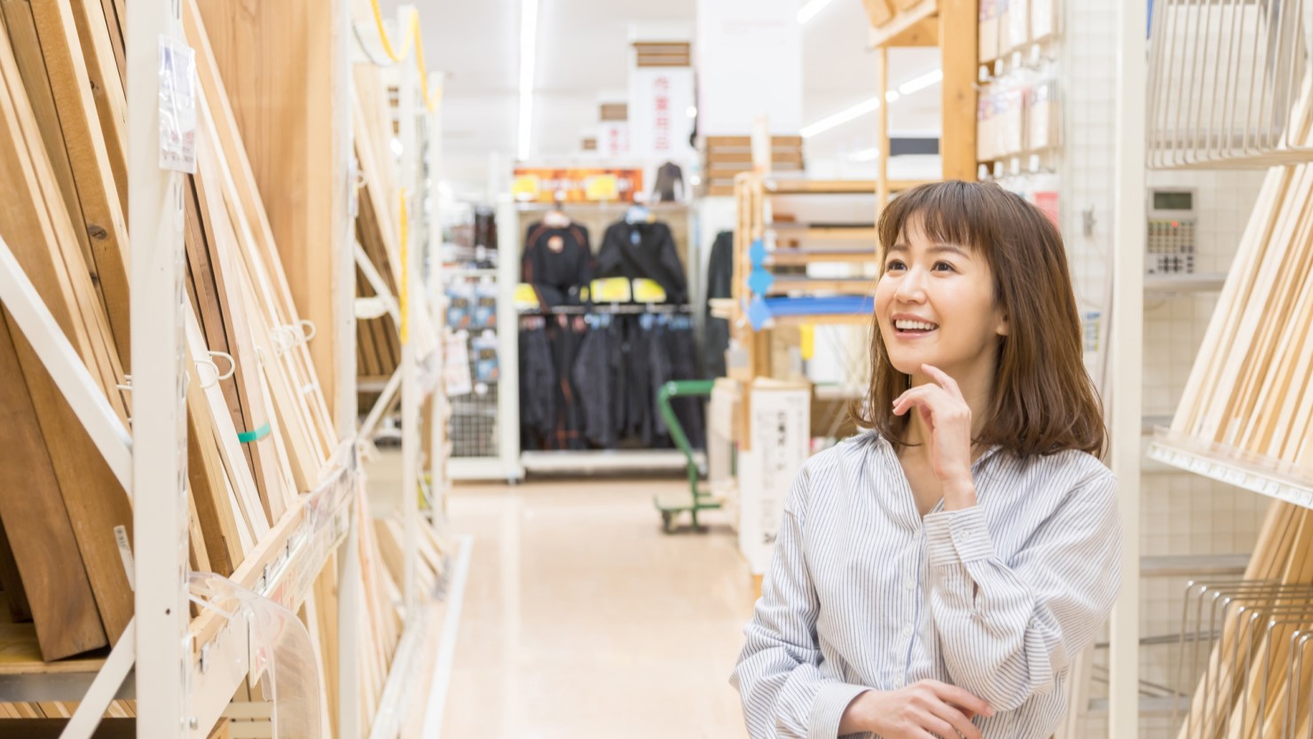  ホームセンターで木材を選ぶ女性