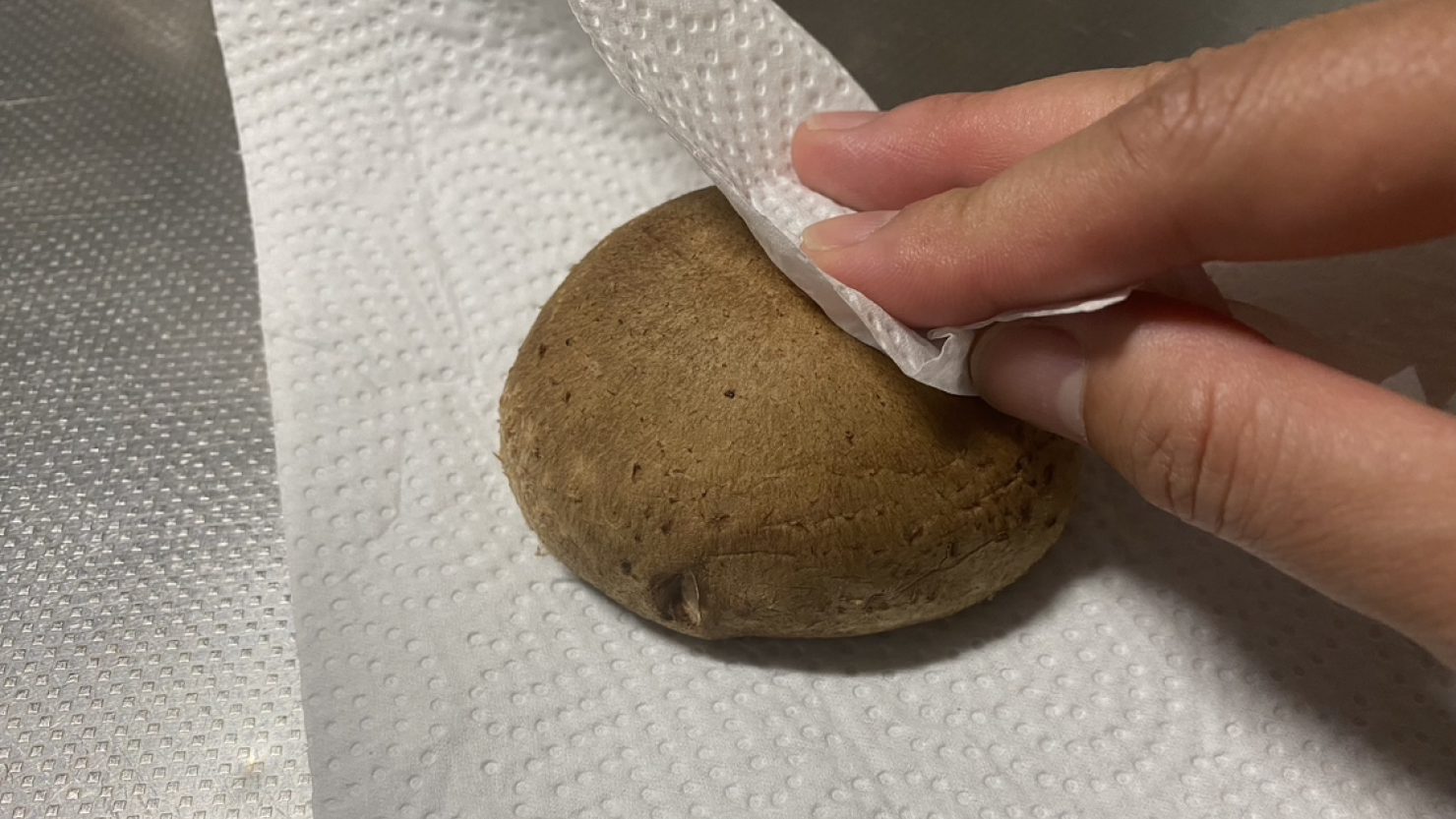 椎茸の表面についた汚れをキッチンペーパーで拭き取る
