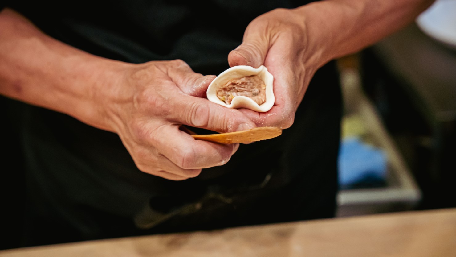 豚ミンチに白菜、ネギなどが入った秘伝の餡を素早く丁寧に包み込む