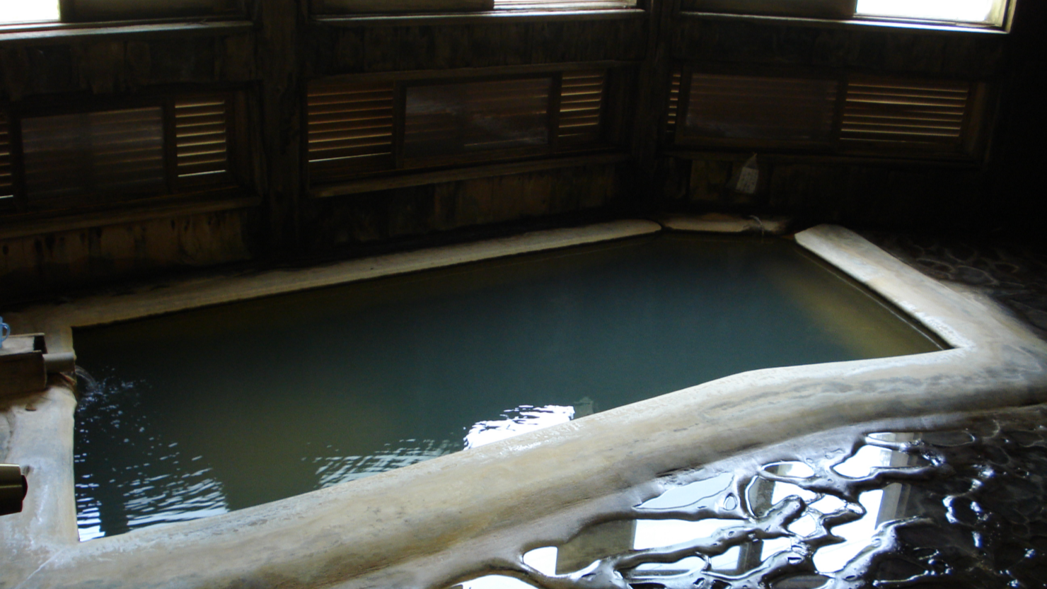 ある温泉の析出物。湯船や床に湯の花が堆積している