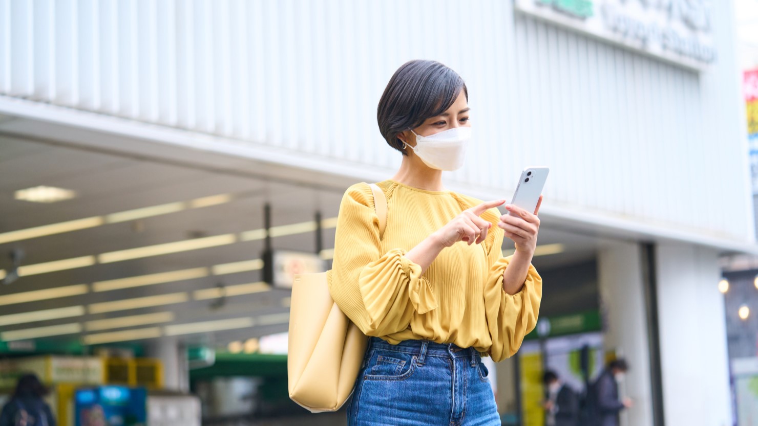 代々木駅で道を調べている女性