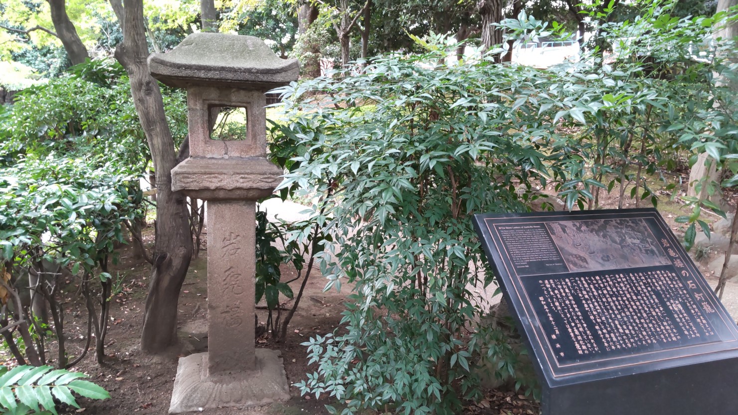 「岩亀楼（がんきろう）」の文字が刻まれた灯篭