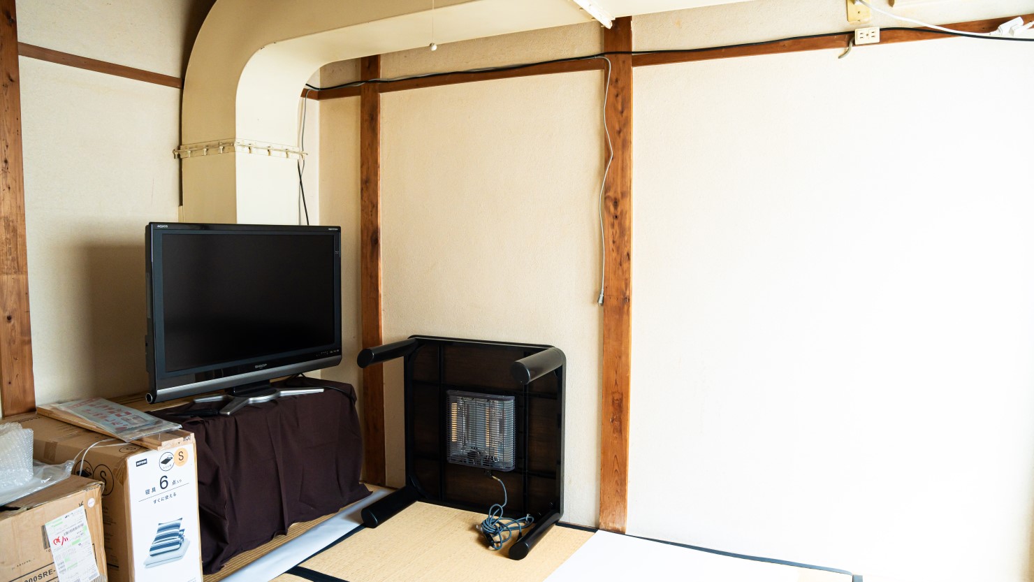 六畳一間の住み込み部屋。部屋のなかには大きな換気扇のダクトが伸びる