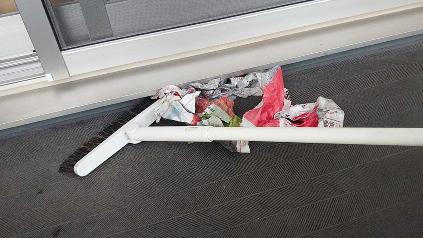 サッシの下はほうきを使って新聞紙を少し押し付けるイメージ　© 橋尾