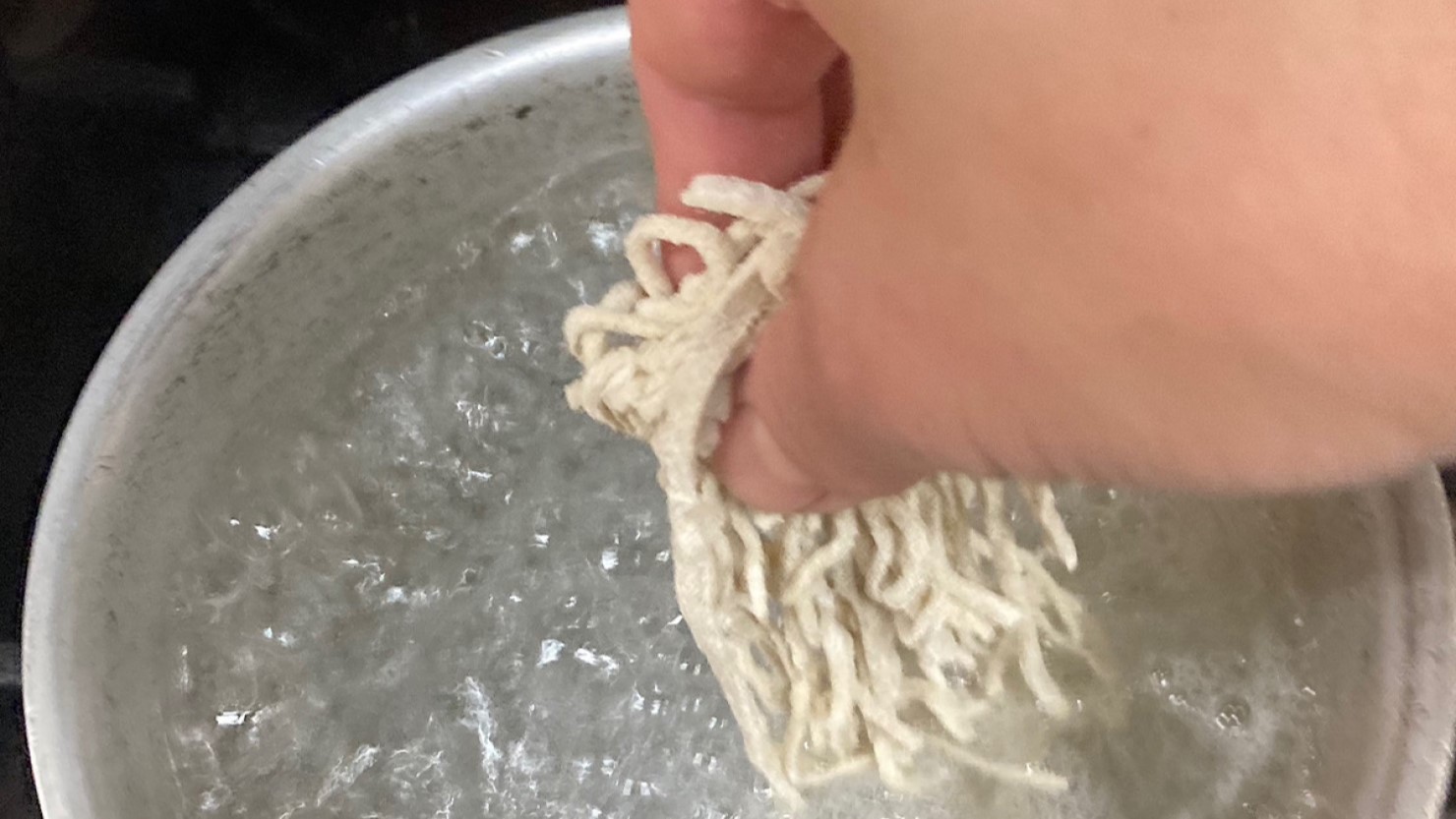 沸騰したお湯に蕎麦を入れていく