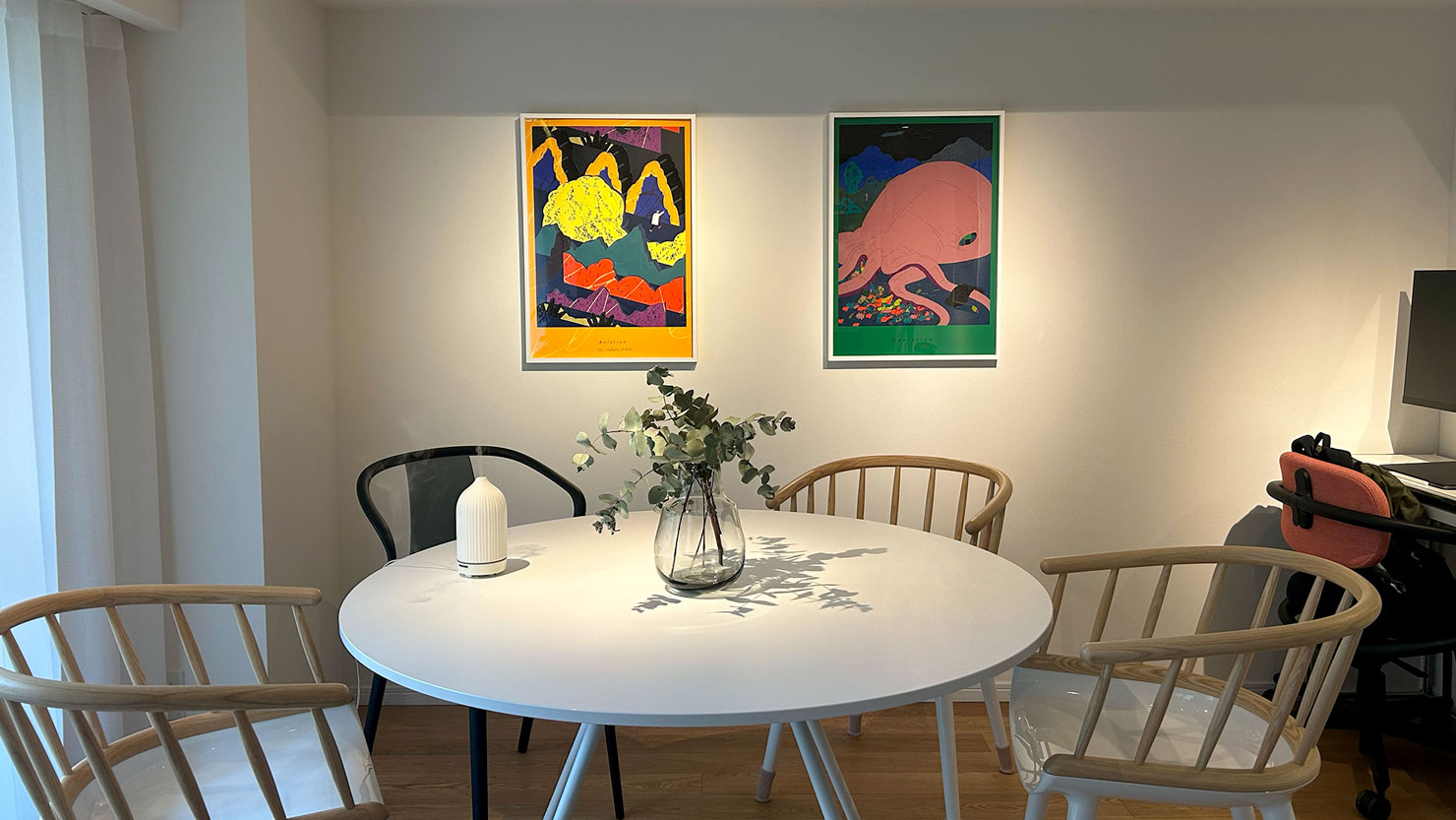 スポットライトで照らされるお気に入りのアートたち。コンクリートだった壁に絵画を飾るのは大変だったとのこと