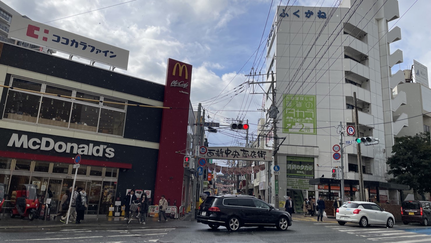 「西新中央商店街」の入り口。飲食店や薬局などが連なっている