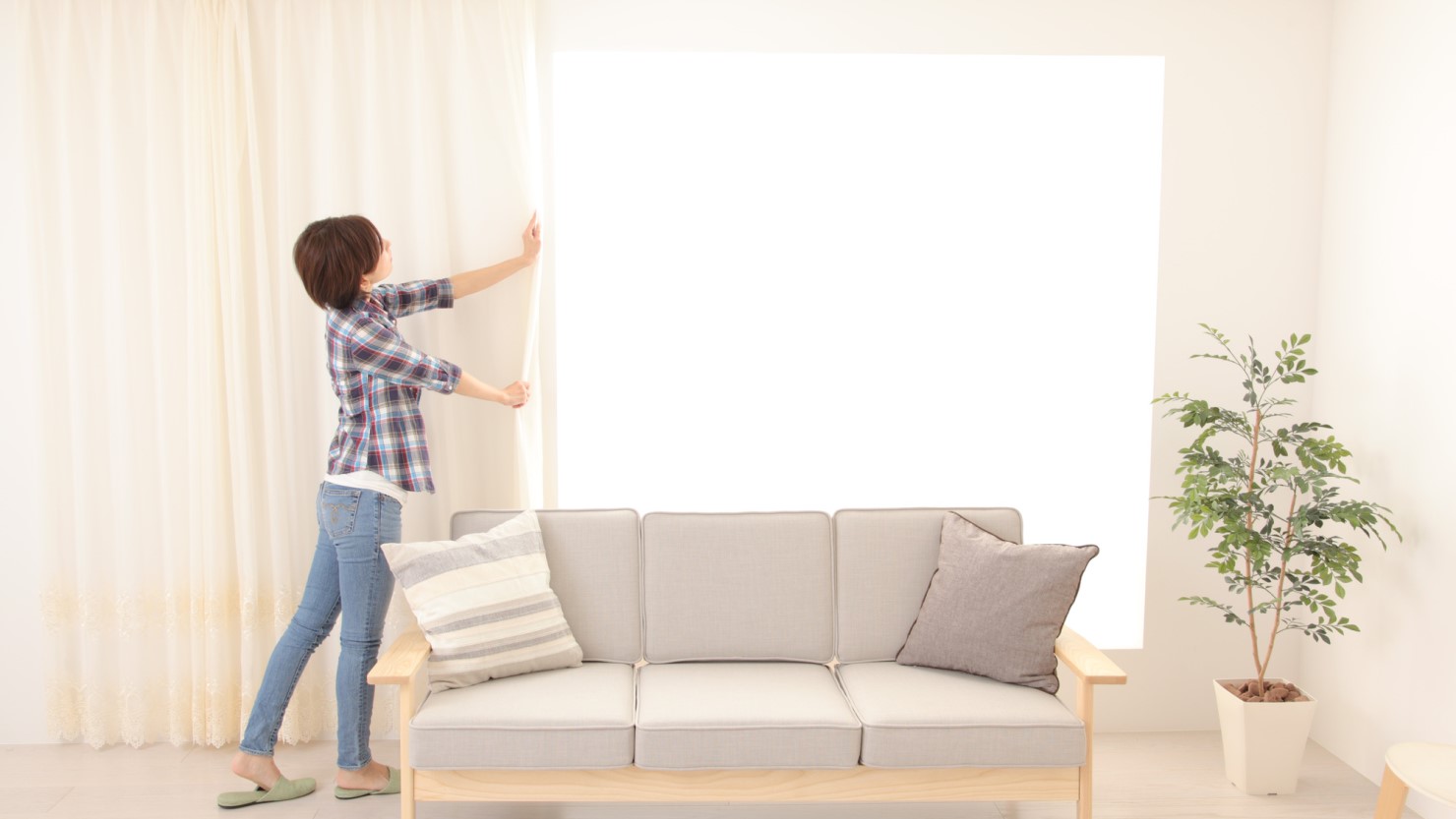 防音カーテンを閉める女性