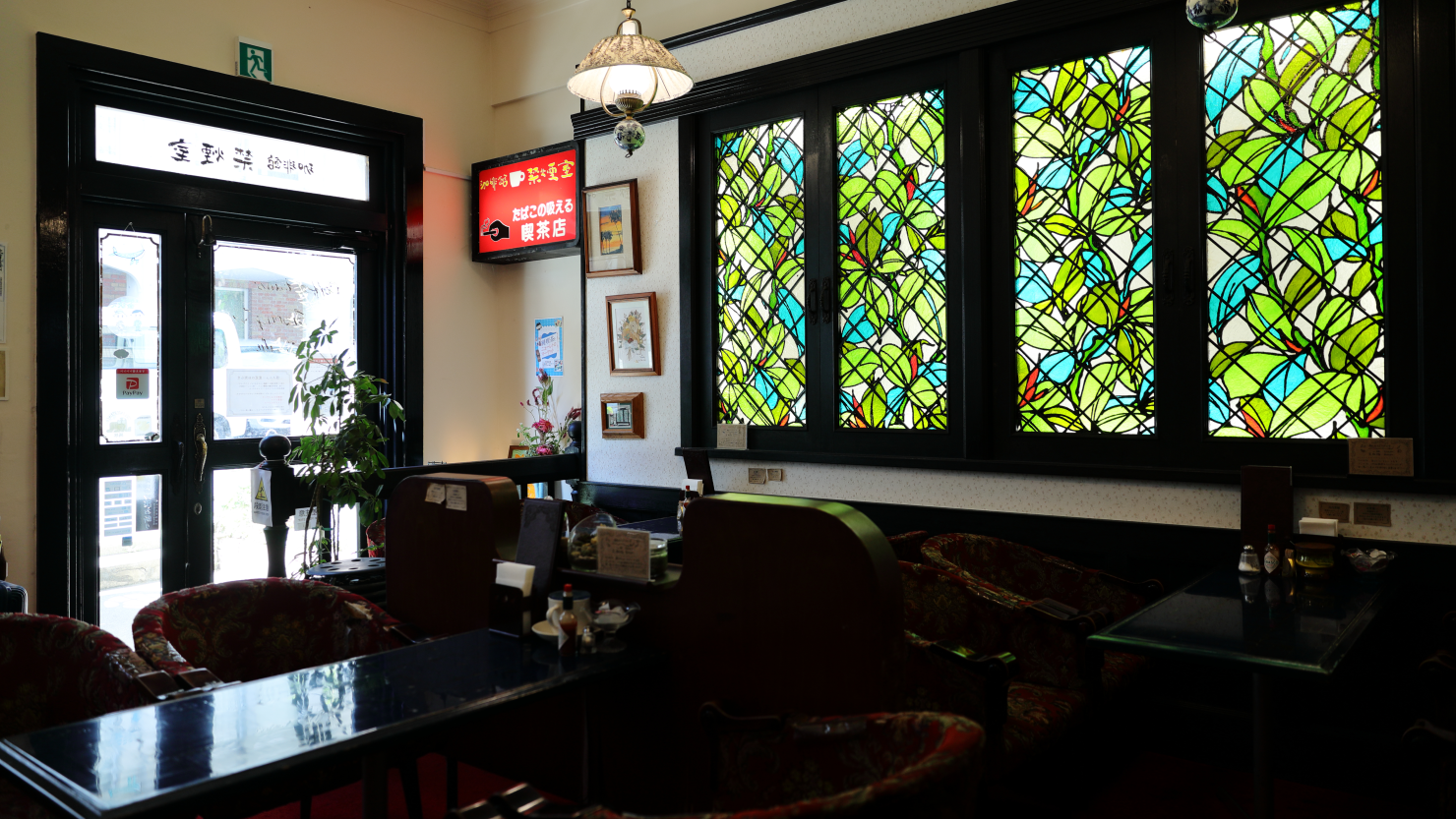 入口の扉も壁のステンドグラスも、テーブルや椅子も「禁煙室」から譲り受けた