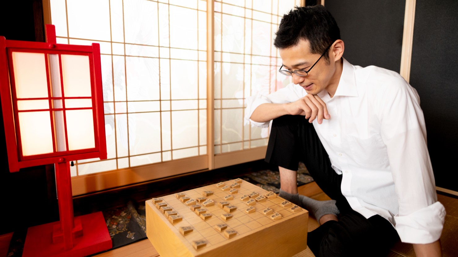 将棋の対戦をシミュレーションする男性