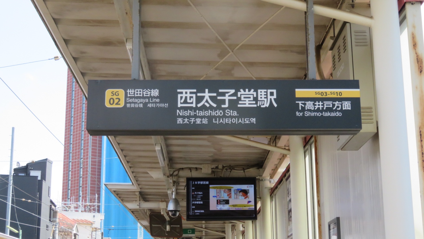 西太子堂駅の表示　後ろにレンガ色のキャロットタワーの一部