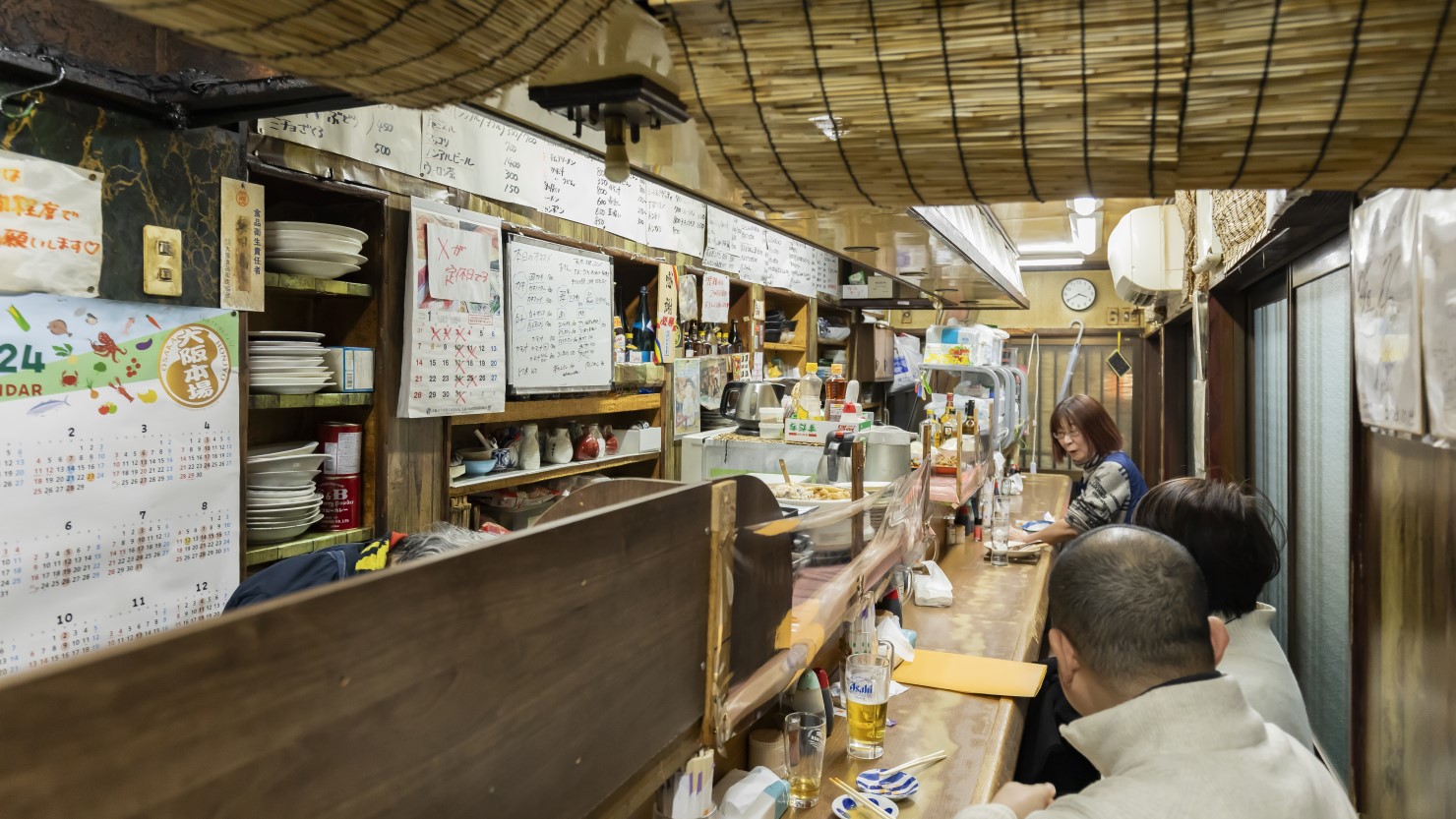 店内は細長いカウンター席が並ぶ。扉が４つあり、どこからでも入店可