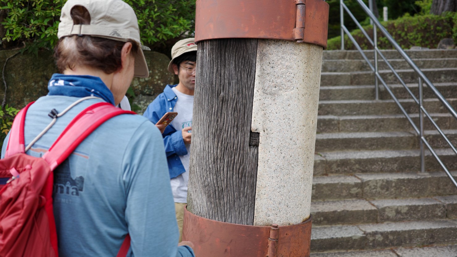 稲荷神社にある木製の鳥居。石を継いで留め具で柱を補強しているよう。あまり見かけないタイプに興味津々のみなさん