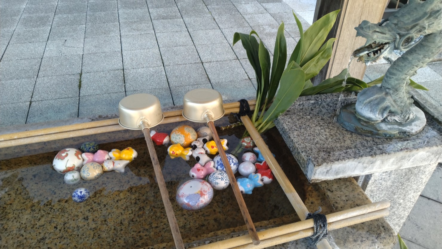 手水舎に浮かべられた猫や金魚・手毬の置物