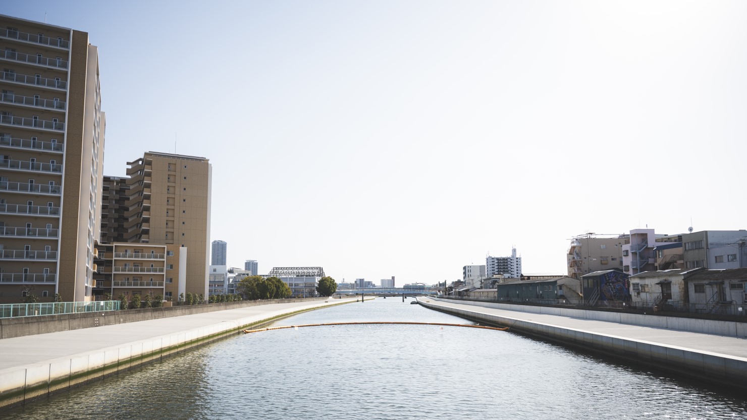 六軒家川を朝日橋から見た景色。右手が梅香、左手は駅前に建てられた新築のマンション。その隣にはスーパーマーケットのライフがある