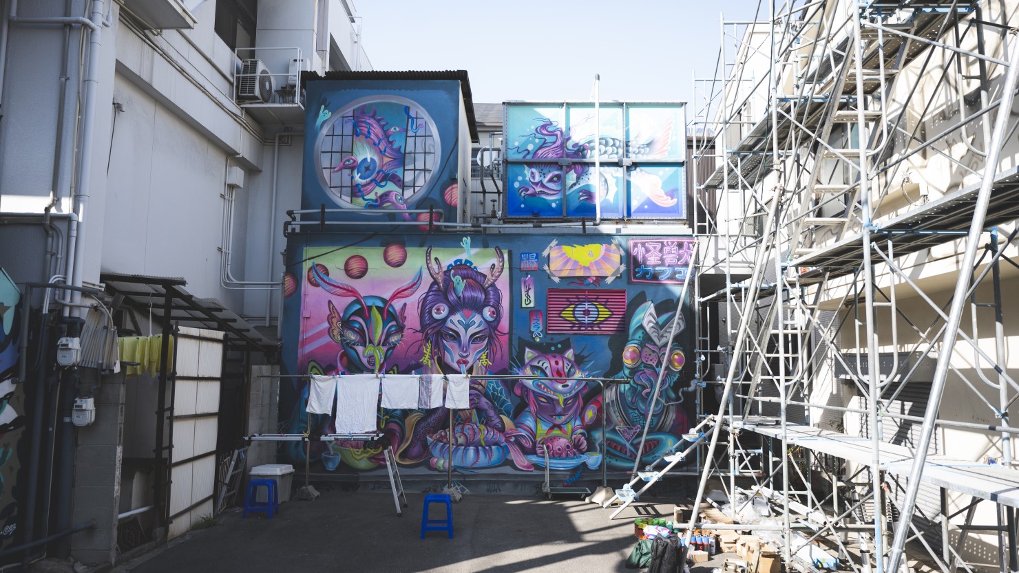 アメリカ人のローレンさんの作品。怪獣カフェと命名されている。そのすぐ横では足場が組まれ、ロシアからやってきたアーティストのFORKさんが新たなミューラルを製作していた
