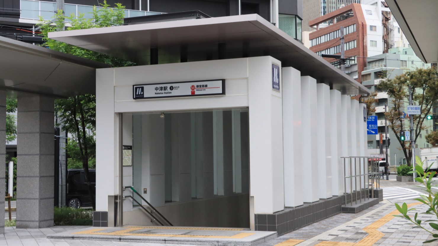 Osaka Metroの中津駅入り口。左手にはタワーマンションが聳え立つ。まさに都会の息吹を感じる駅前です