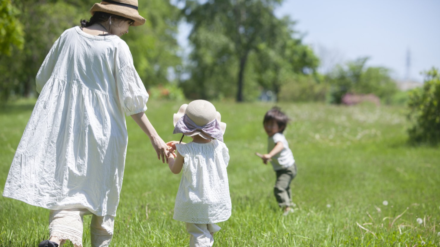 芝生の上を歩く親子