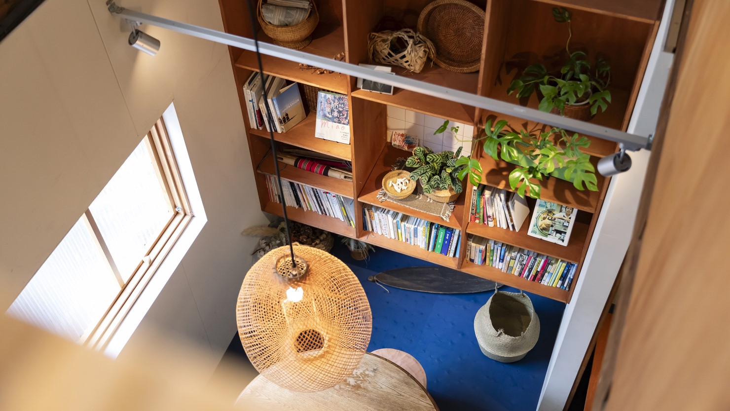 入り口を入ってすぐの窓側の席は吹き抜けに。伸縮自在の竹で編んだシェードはタイの手仕事のもの