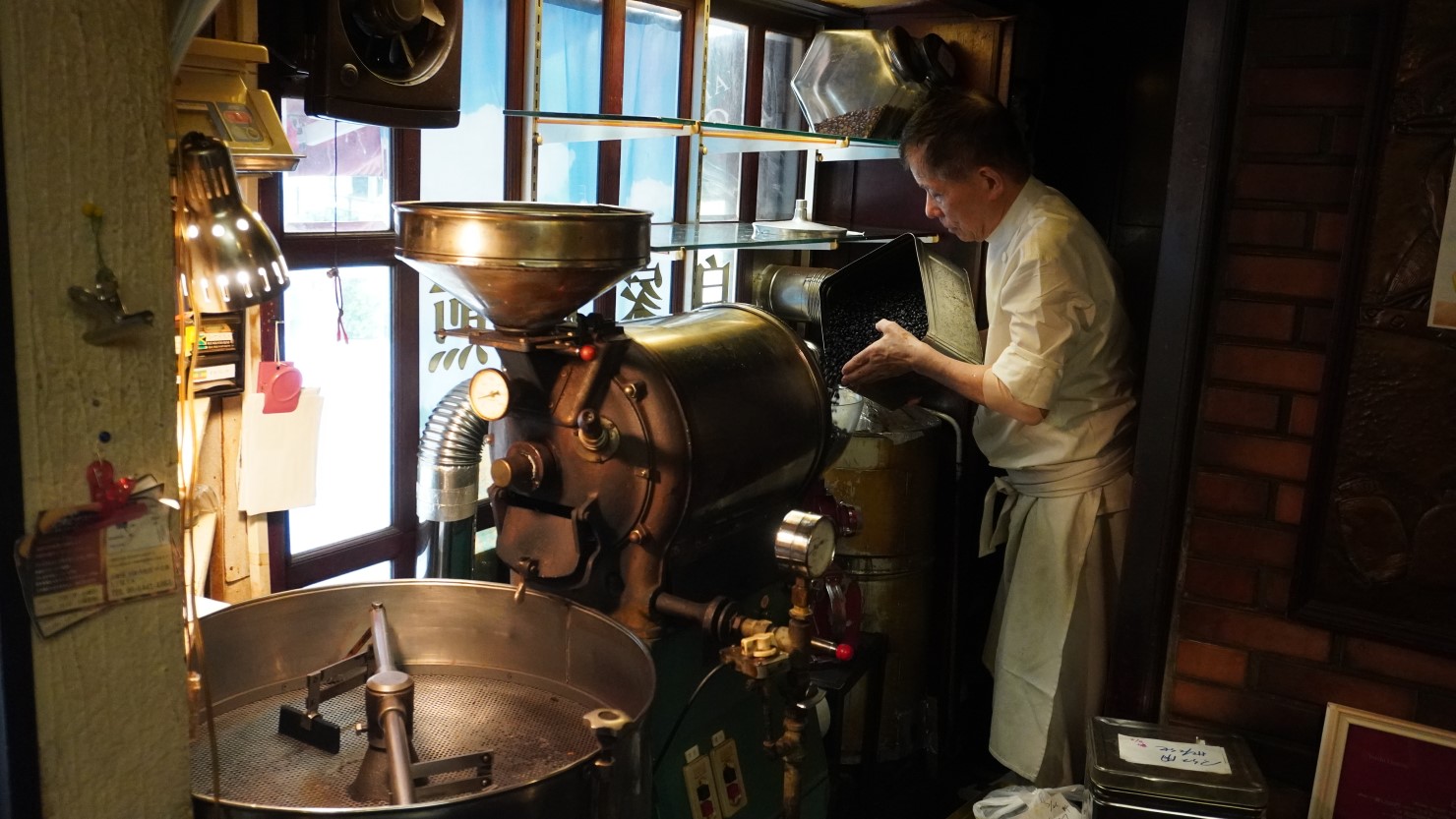 焙煎機を使ってコーヒー豆を煎る智さん。店内に芳しい匂いが漂う