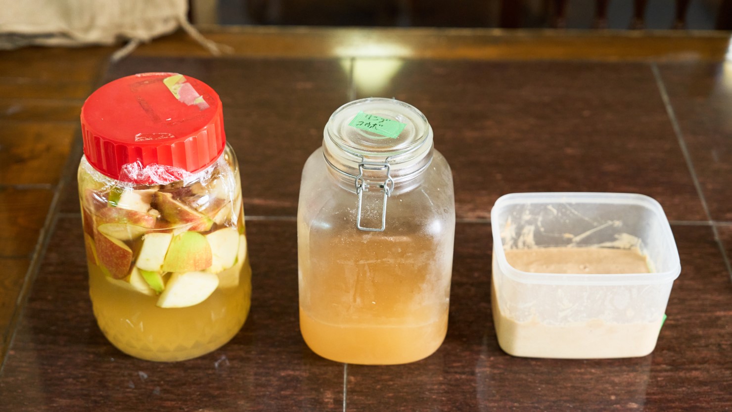 左から発酵途中のりんご酵母、1週間発酵させて完成した発酵液、全粒粉に発酵液を混ぜた元種