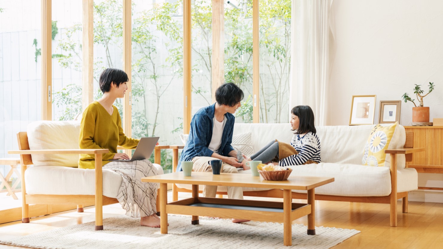 一戸建ての家でくつろぐ家族