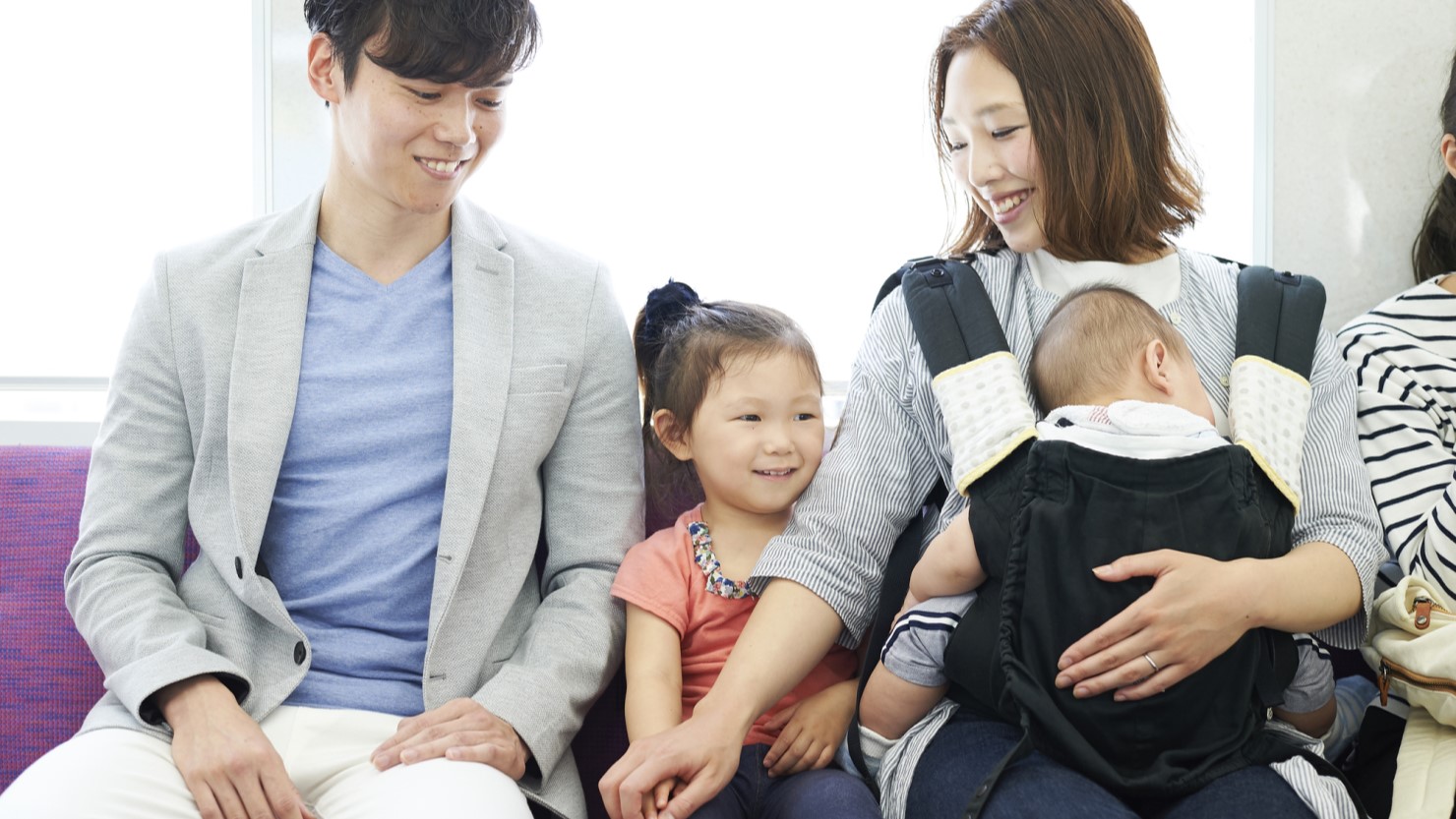 電車で移動する親子