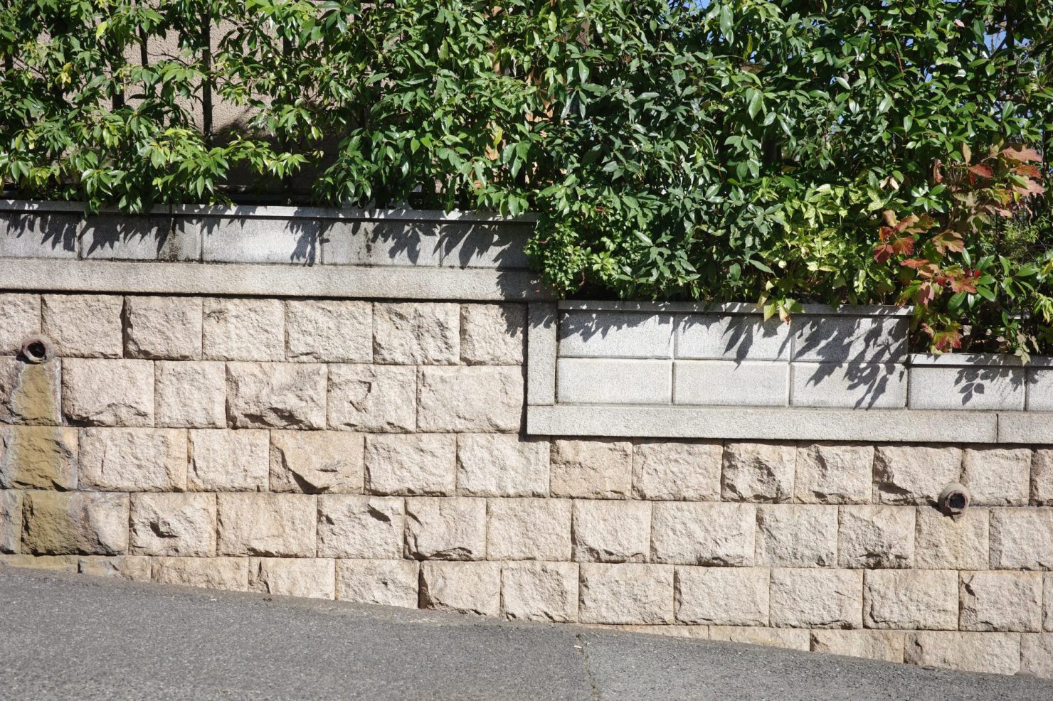 直方体の切石(きりいし)を布積み(横目地が水平に一直線となる積み方)している。既存の石垣を残し、上にさらに別の石積みをしている住宅も多い