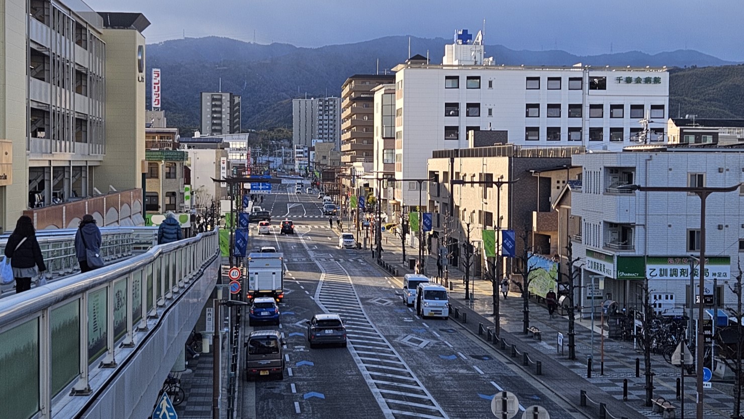 駅前通りの様子。通りの左右に街灯が並び、奥には西山が見える
