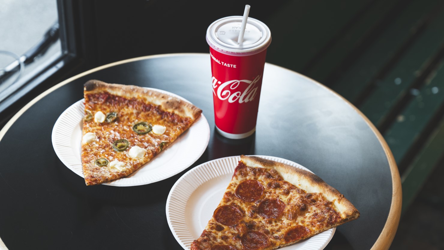 11:30〜15:00まで注文できるランチセットがお得。2SLICE SETは好きなピザ2種類とソフトドリンクが付いて1,000円〜。写真は一番人気のペパロニ（右）とクリームチーズハラペーニョ（左）