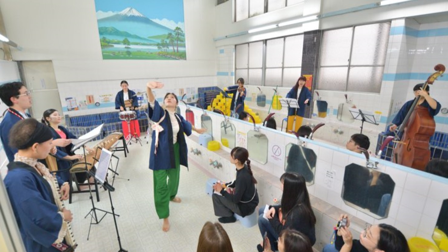 2024年の地域のアートイベント「すみだ向島EXPO」で行われたイベント「あちらこちらin電気湯」の様子。クラシックの楽器を持ってとても楽しそうに飛び回る学生たちの姿を見て「音楽にはすごい力がある」と感じたと大久保さん。イベント後、京島に移り住み、電気湯のバイトにも入っている人もいるといいます。