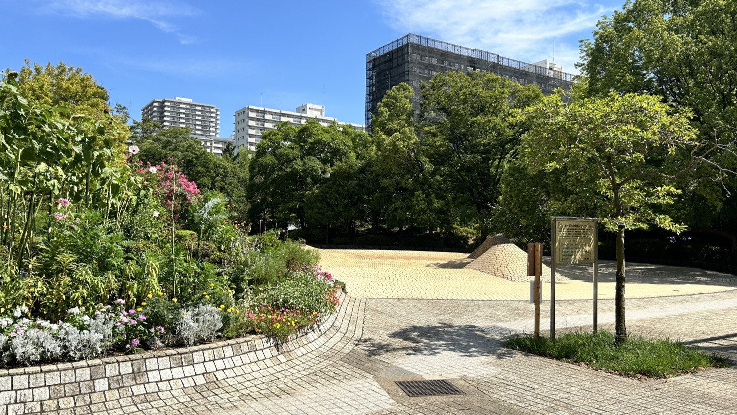 夏の雲公園。花壇奥に見える薄黄色のタイルエリアが「じゃぶじゃぶ池」だ