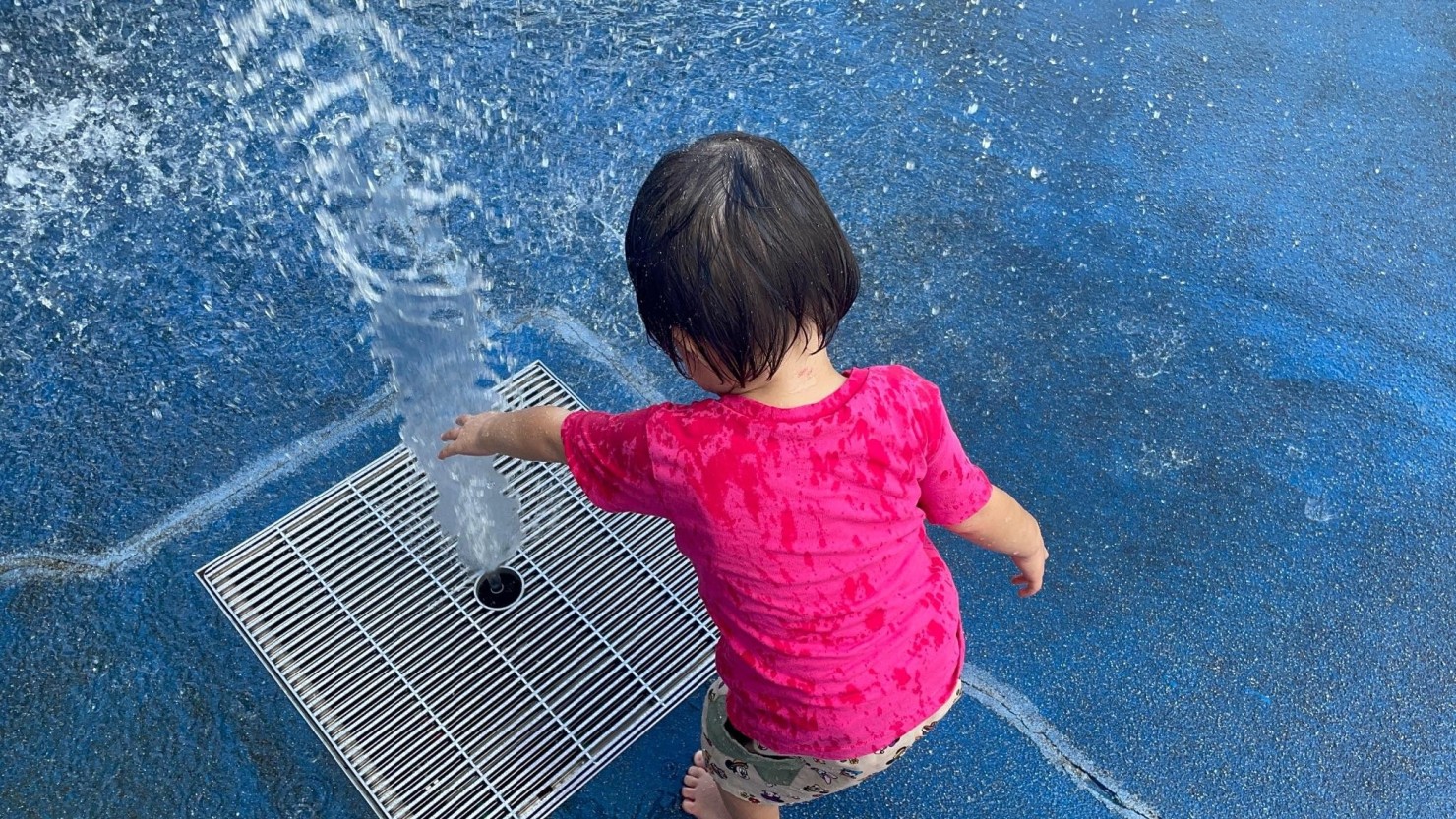 区内の公園にある噴水で遊ぶ娘