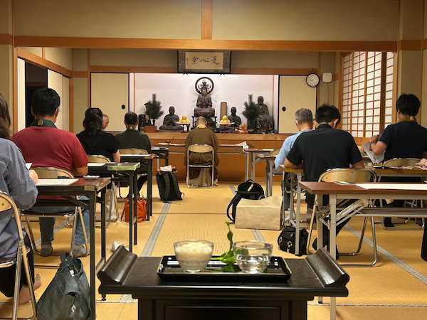 施餓鬼の供え物をして写経をする参加者ら