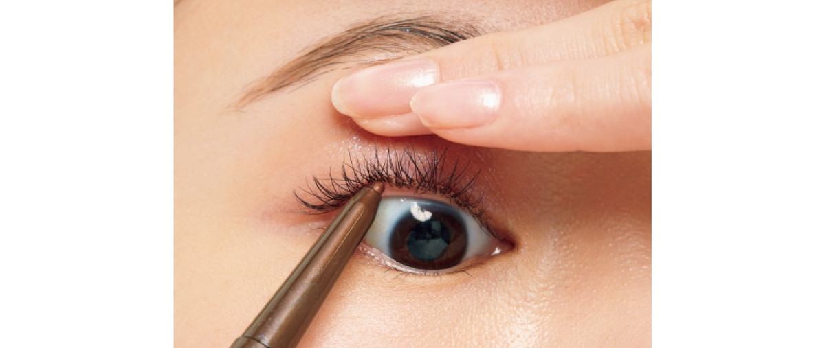 利き手と逆の指で上まぶたを引き上げ、極細のアイライナーを下から差し込むようにしながら、まつ毛の間を色で埋めて。
