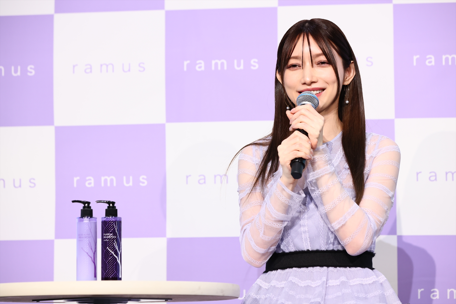後藤真希さんプロデュース「ramus」のシャンプー＆コンディショナーの横で話す後藤真希さん