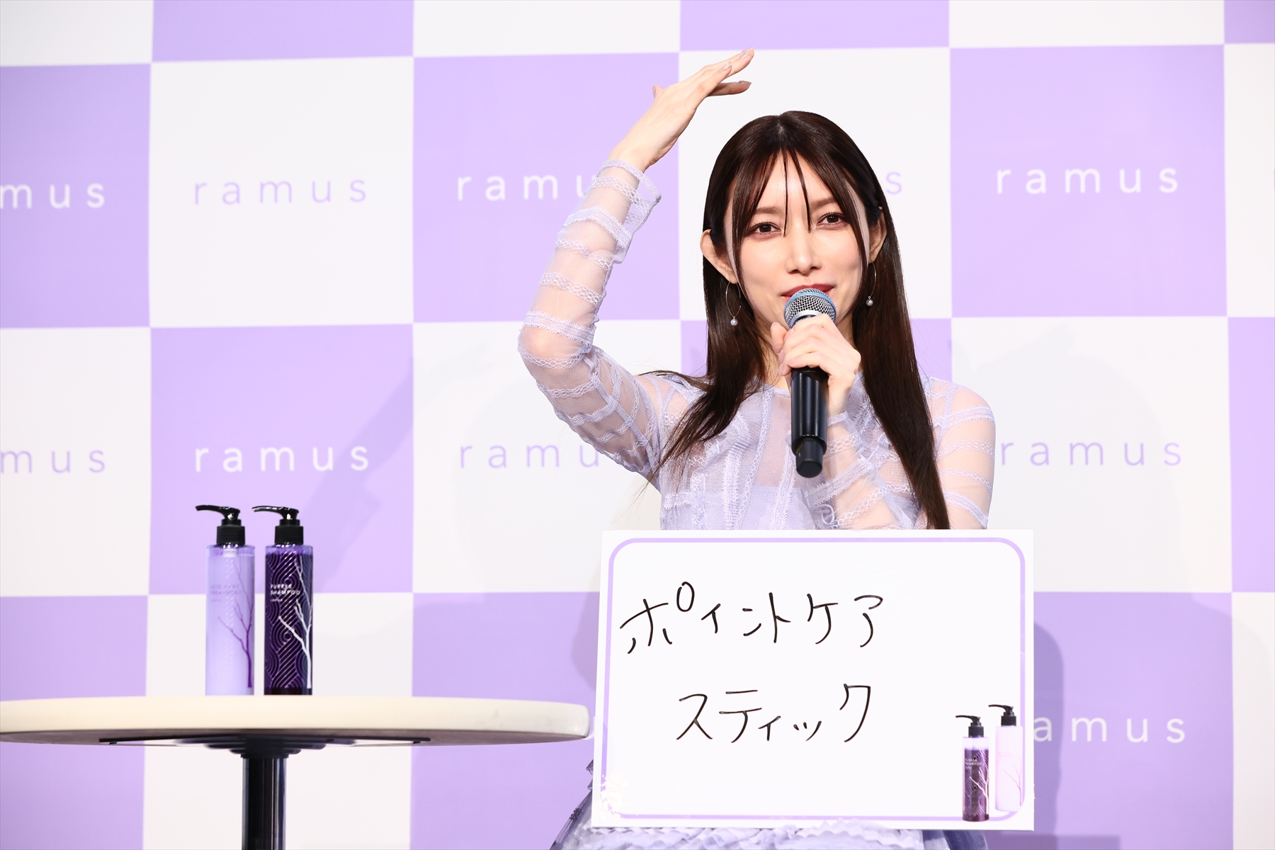 後藤真希さんプロデュース「ramus」のシャンプー＆コンディショナーの横でフリップを持ち質問に答える後藤真希さん