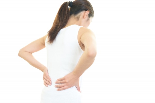 腰をおさえる女性