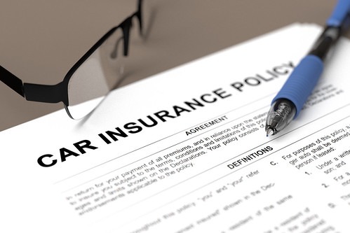 車の保険の書類と眼鏡とペン