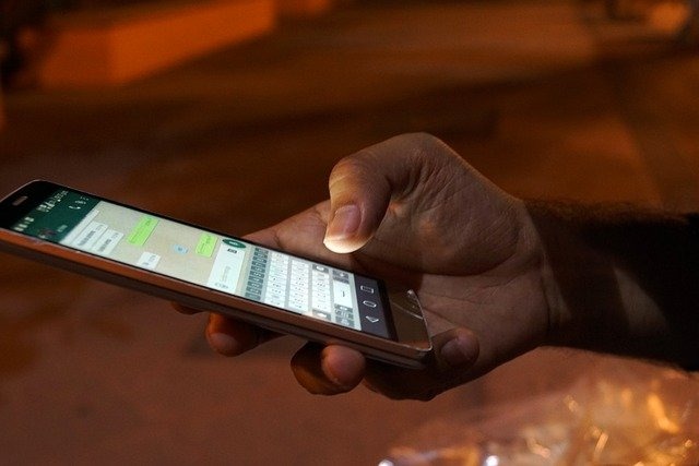 スマートフォンで連絡を取る男性の手