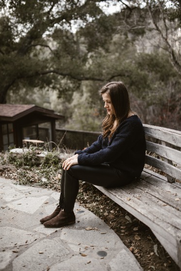 交通事故を思い出してベンチに座って落ち込んでいる女性