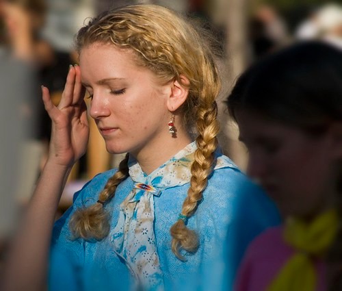 こめかみを押さえる女性