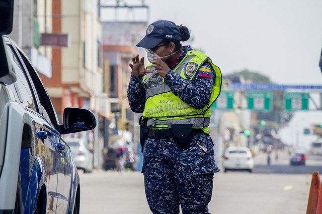 車の運転手と話している警察官