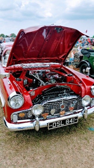 修理のためにボンネットが開いた赤い車