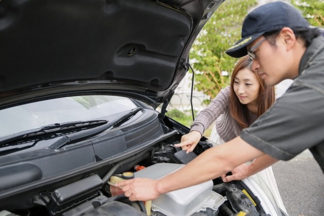 冷却水の交換について説明をする人